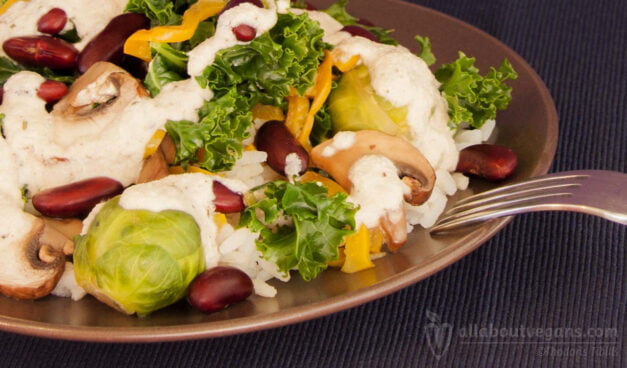 Colorful salad with rice, beans, vegetables and aromatic cashew sauce