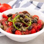 Greek traditional cretan dakos salad. With rusks, tomatoes and olive oil. A vegan recipe.