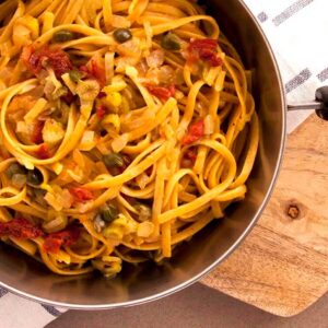 A photo of a pan with yummy linguini with fennel, caper, sun-dried tomatoes and ouzo sauce. A vegan recipe from All About Vegans.