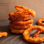 Photo of crispy fried onions rings. A vegan recipe for delicious fried onions from All About Vegans.