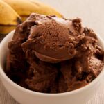 Photo of a bowl with vegan chocolate ice cream made with bananas, peanut butter and almond milk. A vegan recipe from All About Vegans that kids will love!