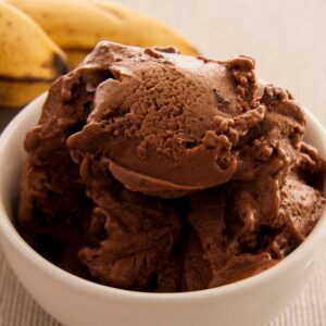 Photo of a bowl with vegan chocolate ice cream made with bananas, peanut butter and almond milk. A vegan recipe from All About Vegans that kids will love!
