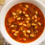 Photo of white navy beans soup with tomato. A vegan and vegetarian recipe from All About Vegans.