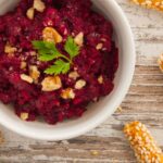 Photo of beetroot walnuts dip / spread vegan and vegetarian recipe accompanied with bread sticks. A raw vegan and vegetarian recipe from All About Vegans.
