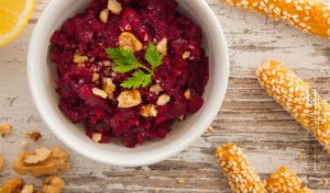Photo of beetroot walnuts dip / spread vegan and vegetarian recipe accompanied with bread sticks. A raw vegan and vegetarian recipe from All About Vegans.