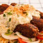 Φωτογραφία πιάτου με τρία σις κεμπάπ πάνω σε πίτα. Σερβιρισμένο με βίγκαν τζατζίκι, κρεμμύδι, ντομάτα, πάπρικα και μαϊντανό. Μια βίγκαν και χορτοφαγική συνταγή από το All About vegans.