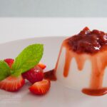 Φωτογραφία vegan πανακότας με σιρόπι φράουλας, σερβιρισμένη με φράουλες και φύλλα δυόσμου