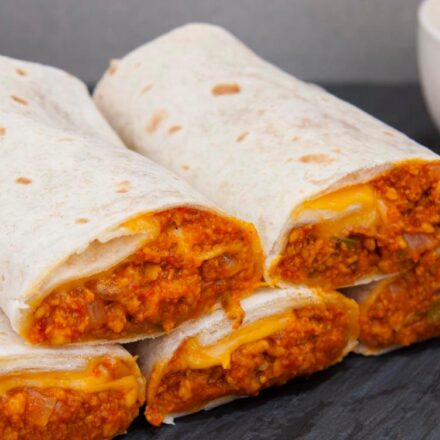 Photo of five vegan burritos with soya mince accompanied by corn and homemade vegan sour cream. A vegan and vegetarian recipe from All About Vegans.