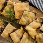 Φωτογραφία κομματιών από vegan μανιταρόπιτα με δεντρολίβανο και τραγανό χειροποίητο σπιτικό φύλλο. Μία vegan, vegetarian και νηστίσιμη συνταγή από το All About Vegans.